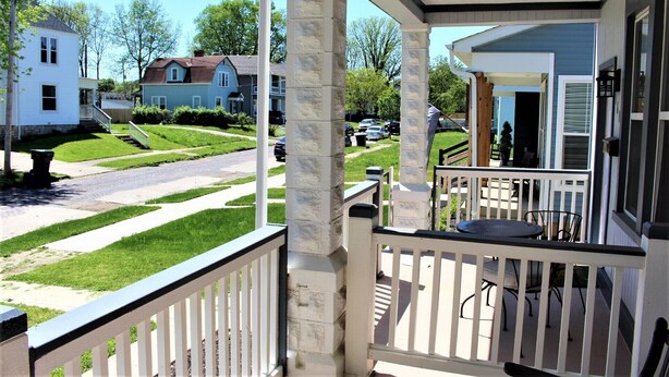 A porch with a stone pillar, a small table, and a chair. - Modern❤️2BR near DT, 8 min walk to Franklin Park/Conservatory/Trolley District (Columbus)