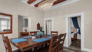 A dining room with a wooden table and chairs, a chandelier, and a mirror on the wall. - Modern❤️2BR near DT, 8 min walk to Franklin Park/Conservatory/Trolley District (Columbus)