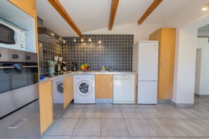 A compact kitchen with a built-in oven, microwave, washing machine, and dishwasher. - La Bastide, duplex villa at 300m from the sea (Hyères)