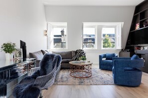 Un salon moderne avec un canapé, un fauteuil et une table basse.