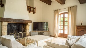 Una sala de estar con chimenea, televisor y sofá.