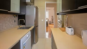 A modern kitchen with a dishwasher, refrigerator, and toaster. - Cosy 1 BDR Apt Belem Sleeps 4 (Lisboa)