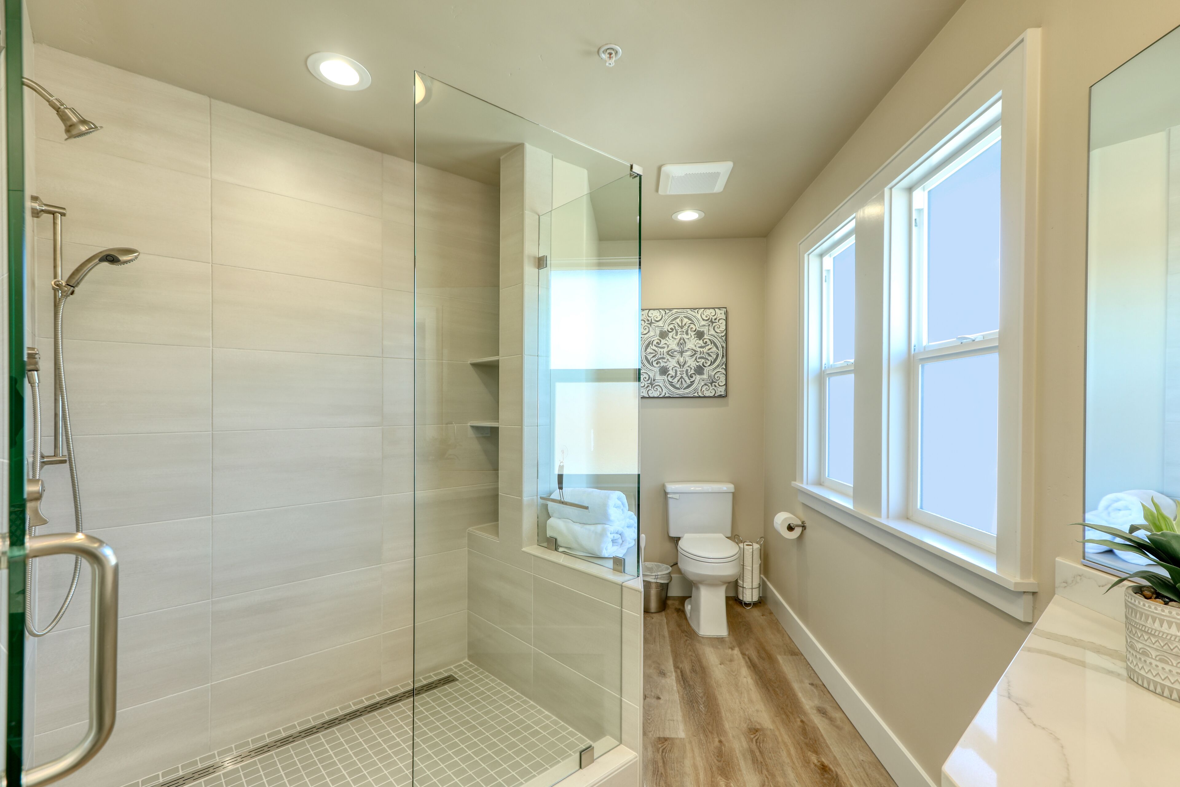 Un baño moderno con ducha de vidrio, inodoro y lavamanos.