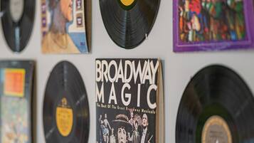 Un mur orné de plusieurs disques vinyle et d’une affiche intitulée « Broadway Magic ».