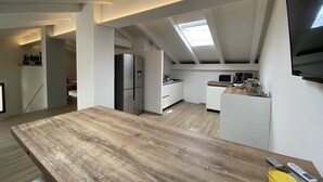 Una cocina moderna con encimera de madera, electrodomésticos integrados y un tragaluz.