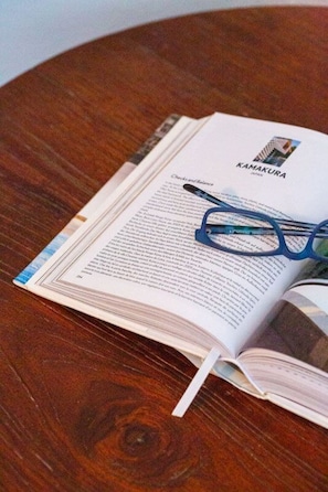 Un libro abierto con gafas encima, sobre una mesa de madera.