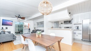 A modern kitchen with white cabinets, a built-in microwave, and a stainless steel refrigerator.