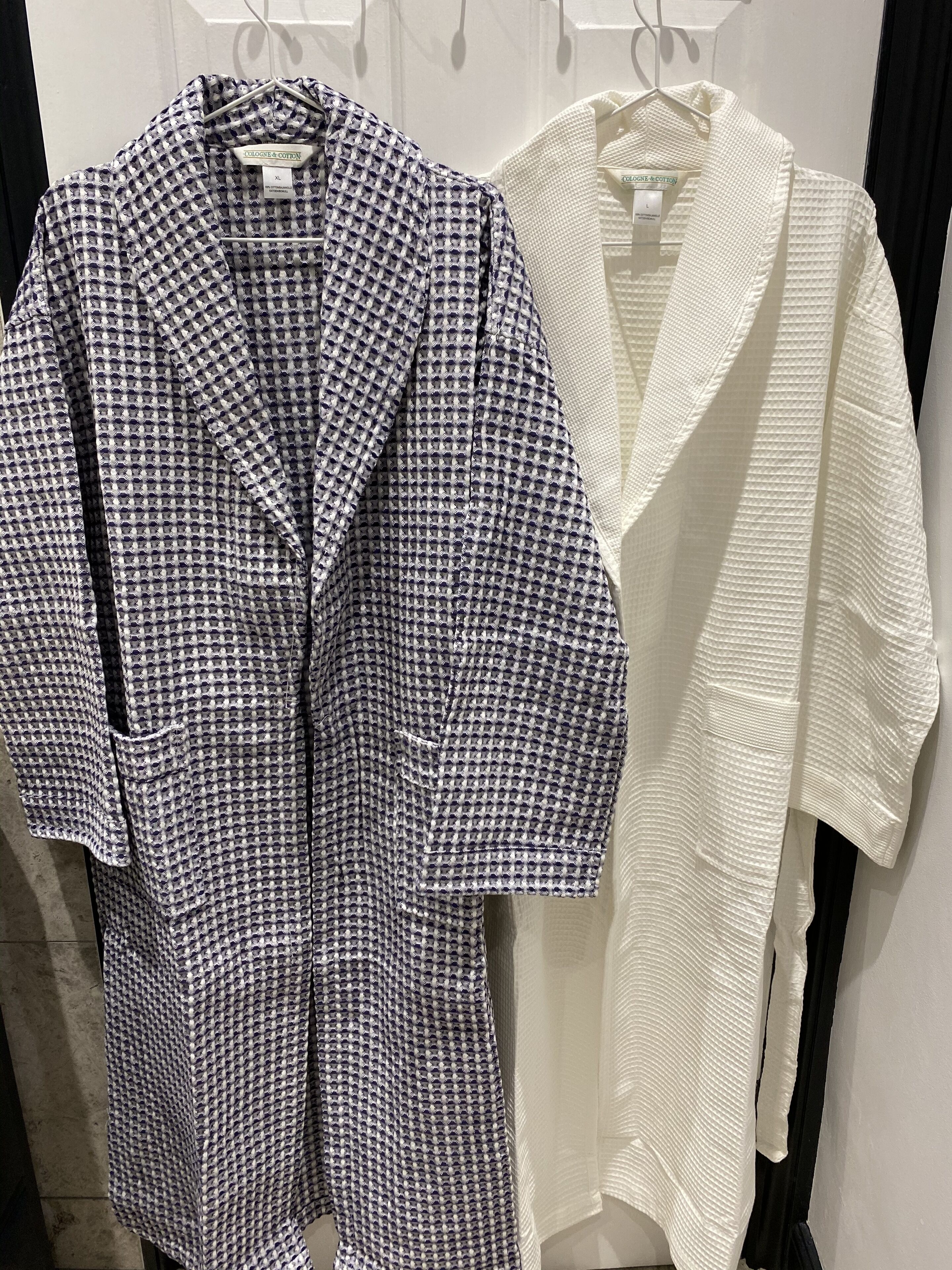 Dos prendas colgadas de perchas, una con estampado de cuadros y la otra lisa.