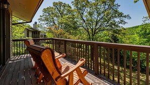 A wooden deck with two Adirondack chairs and a view of a house and lush greenery. - Walk In, Pointe Royale, Indoor Pool, pickleball (Branson)