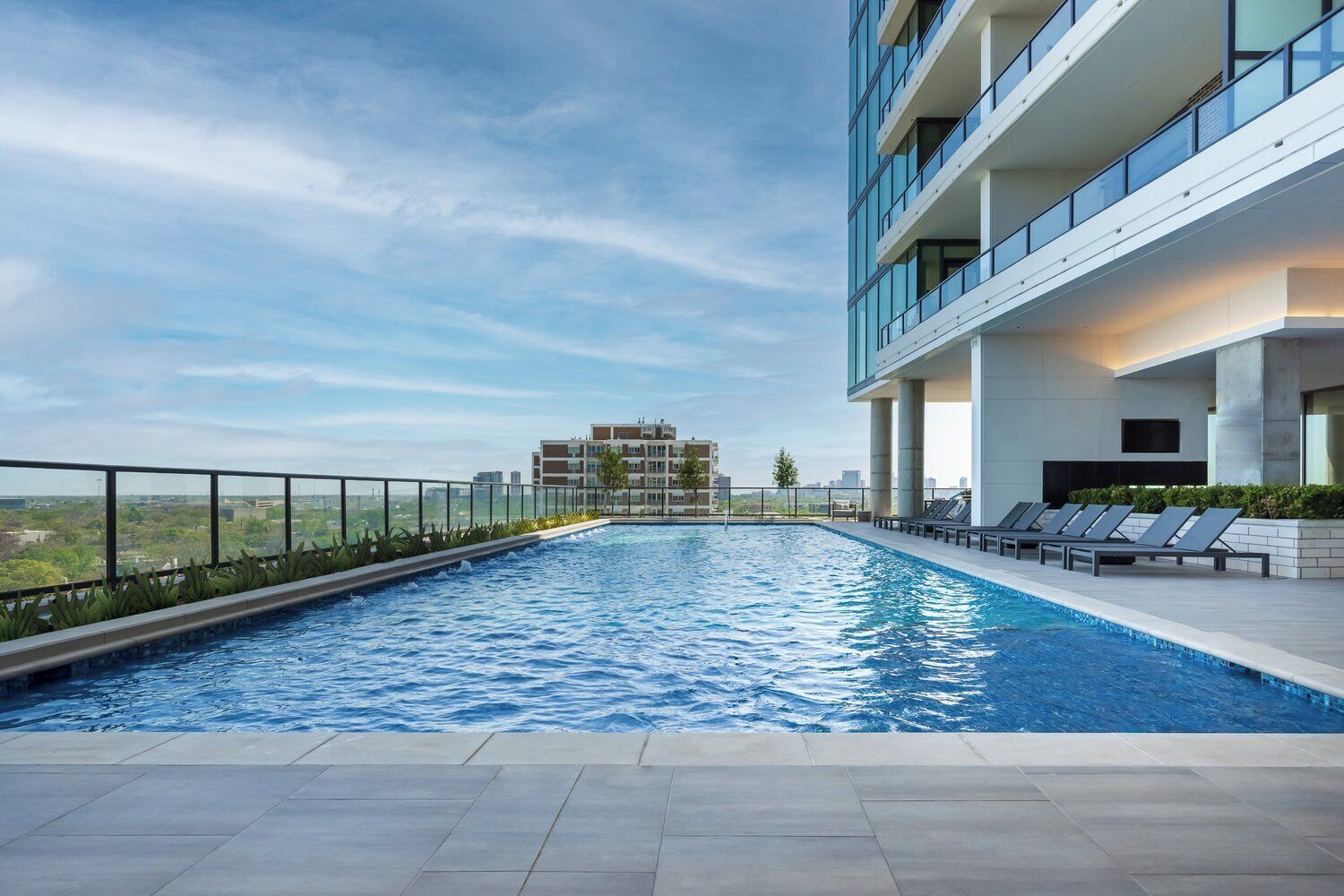 A rooftop swimming pool with a clear view of the cityscape in the background.