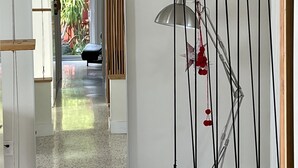 A modern interior with a hallway leading to an outdoor area. There is a large mirror reflecting the hallway and a lamp with a unique design. - Cozy entire house in excellent location , close Brickell , Coconut Grove (Miami)