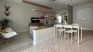 A modern kitchen with a central island, white chairs, and a dining table. - Cozy entire house in excellent location , close Brickell , Coconut Grove (Miami)