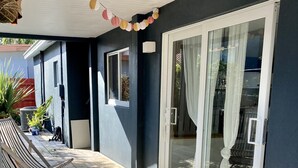 A covered outdoor area with a wooden deck, a bench, and potted plants. - Cozy entire house in excellent location , close Brickell , Coconut Grove (Miami)