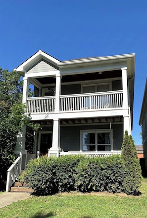 A two-story house with a balcony, a front porch, and a well-maintained hedge. - Licensed, 5 Min To Downtown 4BR, 3.5BA with 2 Master Suites (Nashville)