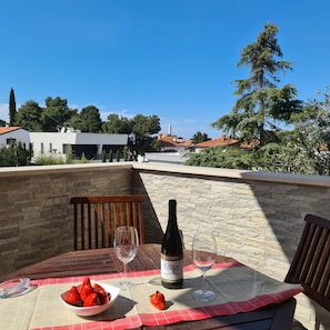 Enjoy a romantic dinner for two on this outdoor space with a table set amidst a serene residential view.
