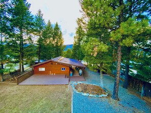 Escape to a serene cabin surrounded by nature, with a porch and a view of a tranquil body of water.