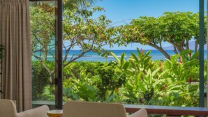 A room with a view of the ocean, a balcony with plants, and a window with curtains. - Oceanfront luxury 3bd condo on Baby Beach (Lahaina)