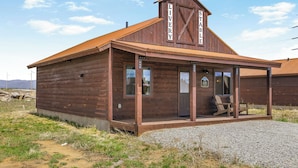 A wooden building with a covered porch and a sign reading 'LIVERY STABLE'.