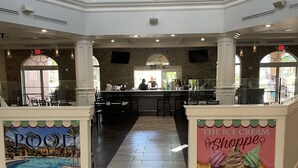 A hotel lobby with a pool view, a restroom sign, and an arcade sign. - Private Room In Regal Palms Resort, Davenport FL, Sleeps 2 (Davenport)