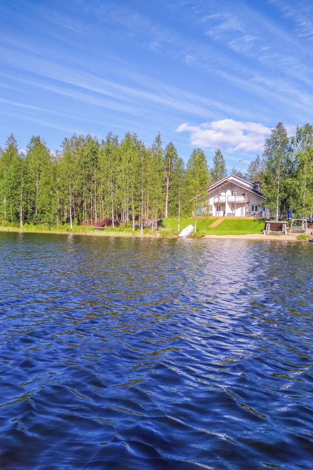 Une propriété au bord du lac, avec un chalet, entourée d’arbres et donnant sur un lac paisible.