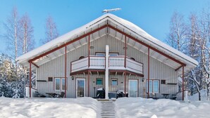 A large, single-story building with a balcony, surrounded by snow.