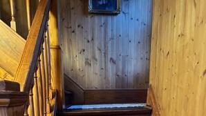 A wooden staircase with a handrail and a picture on the wall. - Visit the farm! (Dekalb)