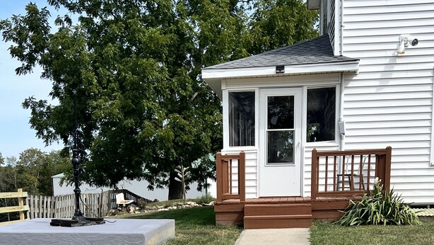 A concrete staircase leading to a white house with a porch. - Visit the farm! (Dekalb)