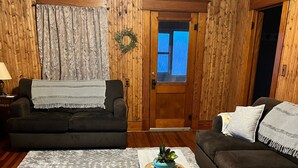 A living room with two sofas, a coffee table, and a rug. - Visit the farm! (Dekalb)