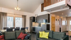 A modern living room with two sofas, a dining table, and a kitchen area.