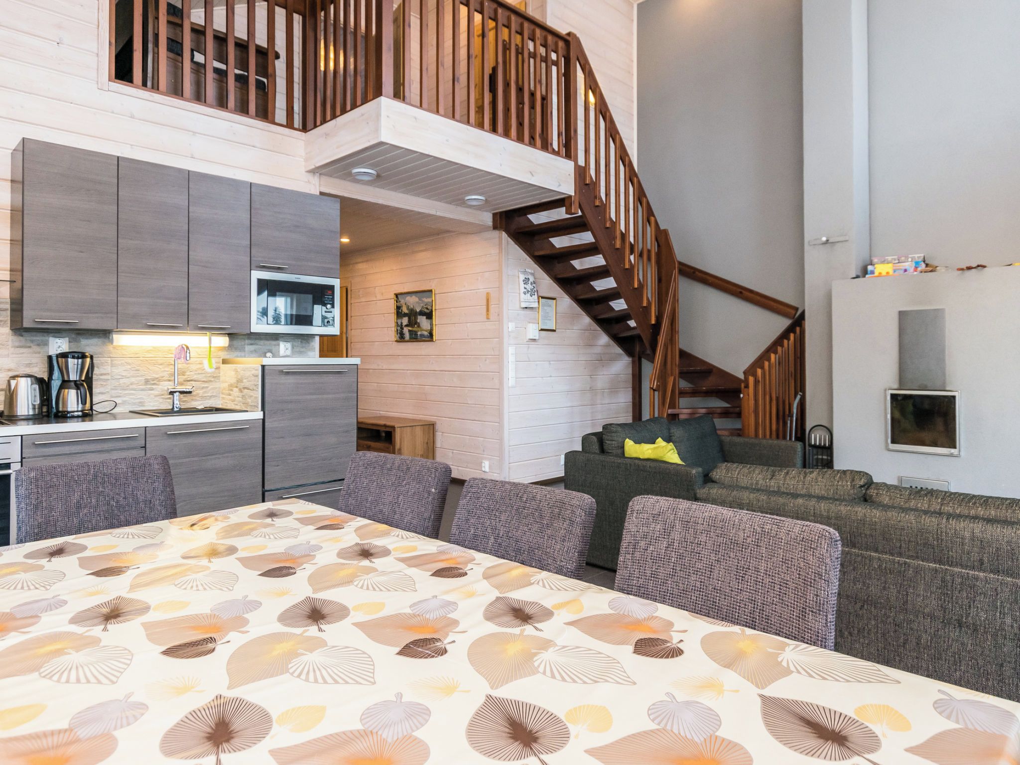 Een modern interieur met een keuken, een eethoek en een trap.
