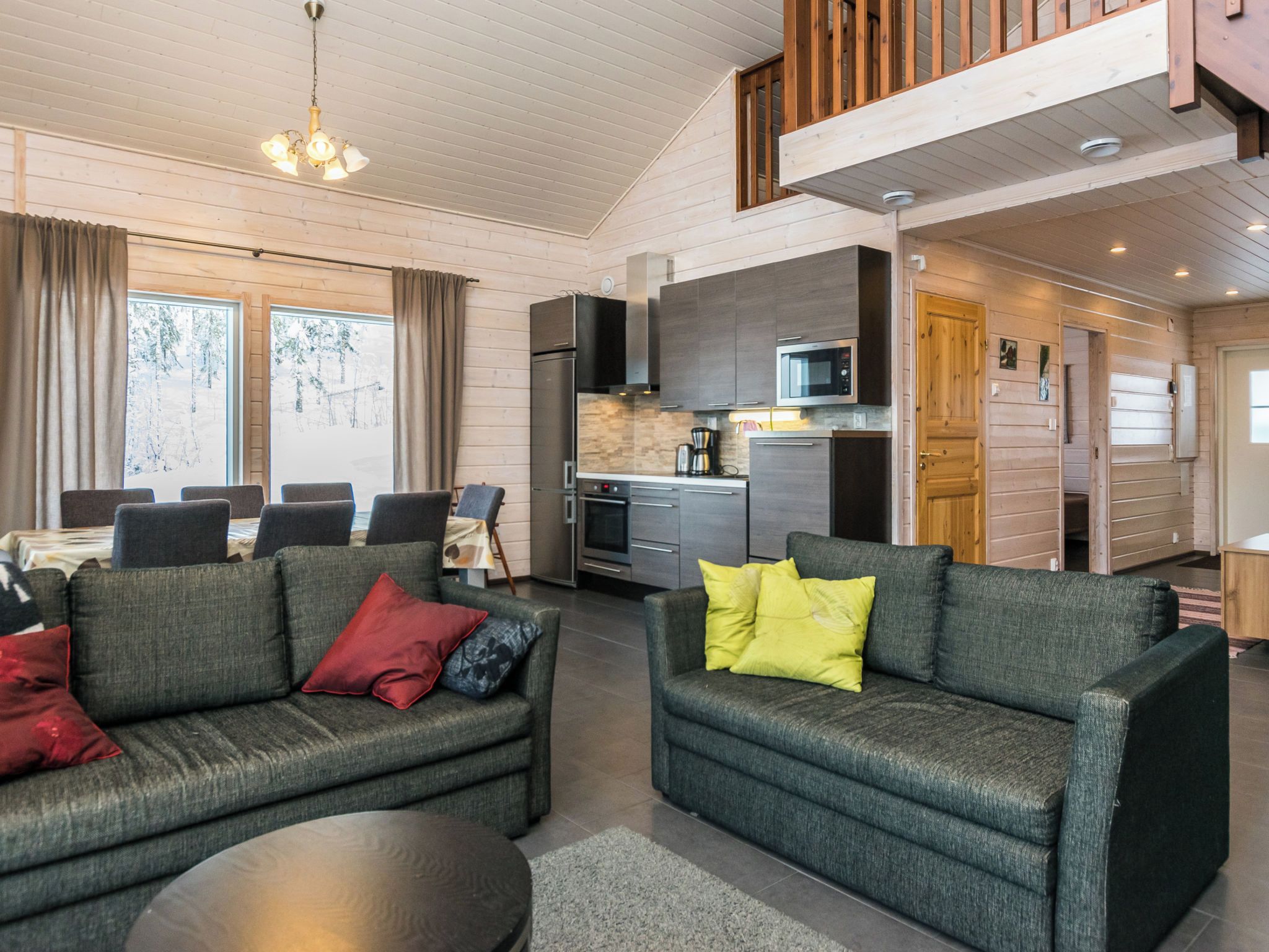 Een moderne woonkamer met een bank en een eethoek met een tafel en stoelen.