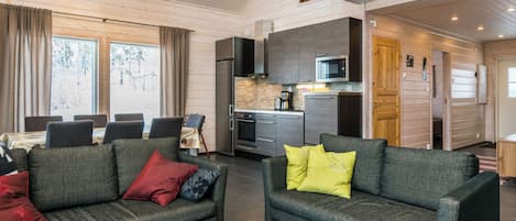 A modern living room with a sofa and a dining area with a table and chairs.