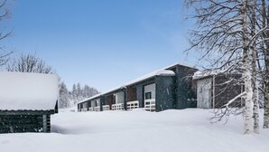 Un edificio cubierto de nieve con una estructura larga y estrecha y un paseo techado.