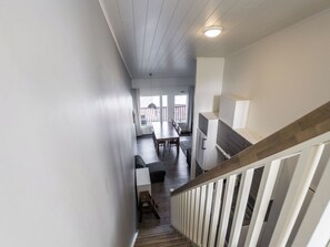 Un escalier menant à une salle à manger offrant une vue sur l’extérieur.