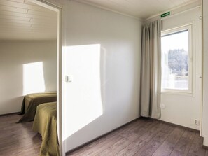 A room with a bed, a window with curtains, and a door labeled 'Varatie'.
