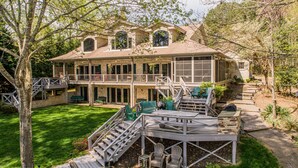 A two-story house with a balcony, outdoor seating area, and a stone fireplace. - GREAT for FAMILIES, beautiful waterfront, kayaks, firepit, pool table, & more! (Henrico)