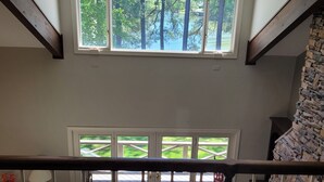 A high-ceilinged room with large windows overlooking a green landscape. - GREAT for FAMILIES, beautiful waterfront, kayaks, firepit, pool table, & more! (Henrico)