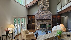 A spacious living area with a stone fireplace, comfortable seating, and a large kitchen with granite countertops. - GREAT for FAMILIES, beautiful waterfront, kayaks, firepit, pool table, & more! (Henrico)