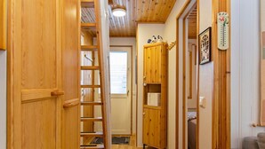A wooden interior with a staircase, a wooden cabinet, and a thermostat on the wall. - Hallantytär a2 paritalo by Interhome (Hyrynsalmi)