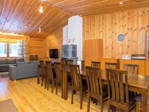 Un interior de madera con una mesa de comedor, sillas, un sofá y un televisor.