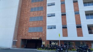 A multi-story building with a brick facade, a garage entrance, and a motorcycle parked in front.
