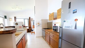 Cozinha moderna com armários de madeira, geladeira de aço inoxidável e forno embutido.
