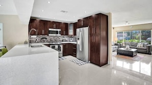Una cocina moderna con armarios de madera oscura, electrodomésticos de acero inoxidable y una isla grande.