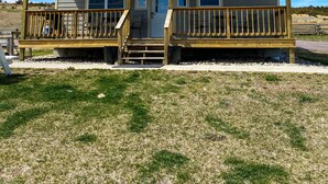 A two-story house with a front porch, a driveway, and a grassy yard. - Shoreline Cottage SD (Oacoma)