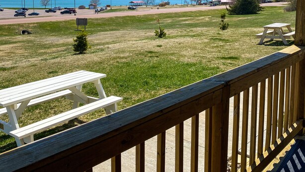 A view from a porch overlooking a grassy area with picnic tables and a picnic shelter. - Shoreline Cottage SD (Oacoma)