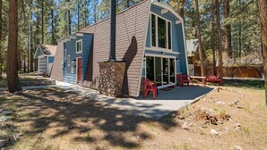 A modern cabin with a stone foundation, large windows, and a chimney. - Sherwood Pines - Pool Table, Fireplace, Fenced Yard (Big Bear City)