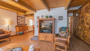 Ein gemütliches Wohnzimmer mit Holzmöbeln, einer Fernsehschrank und einer Wand mit Holzpaneelen.