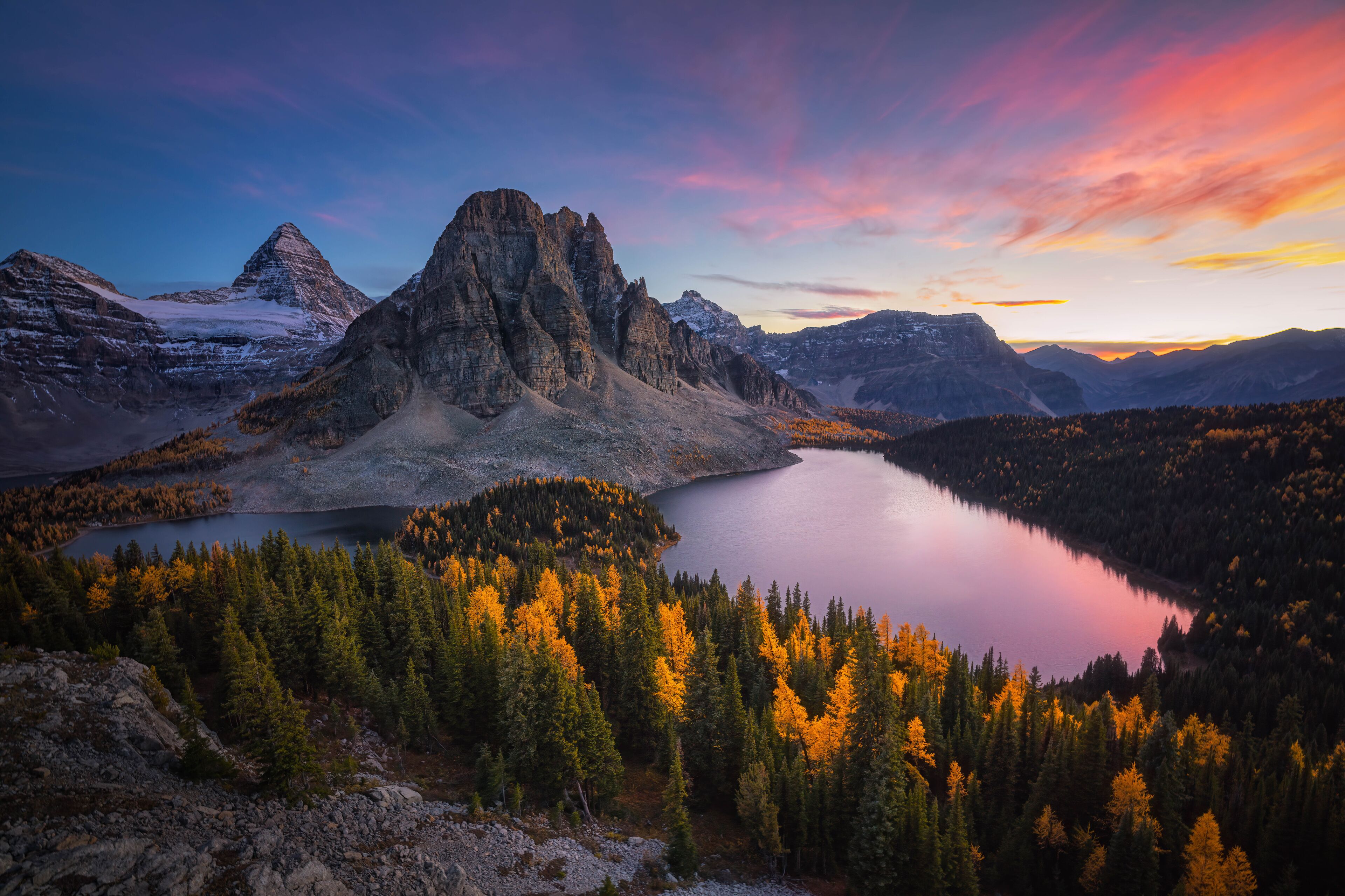A mountain landscape with a lake and forest.
