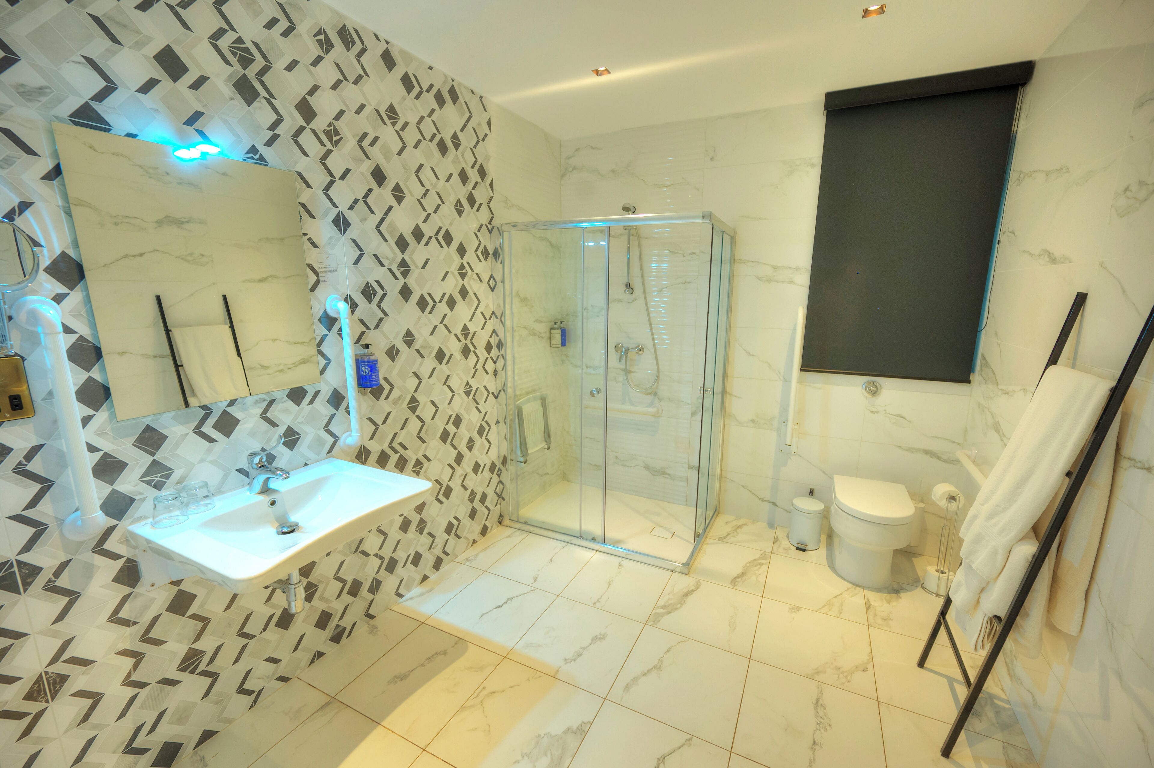 Une salle de bain moderne avec une douche à parois de verre, un lavabo blanc et des toilettes.
