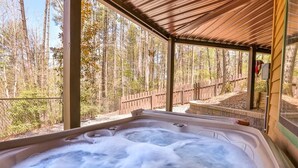A hot tub with a wooden roof and a view of a forest. - A Tucked Away Lodge | Ellijay, GA (Ellijay)